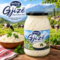A glass jar of extra milk cottage sheep and farmer cheese with a black lid, set on a rustic wooden table with a bowl of cheese, parsley, and a scenic Albanian mountain landscape with cows in the background.